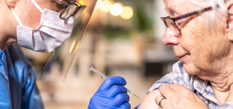 En vårdpersonal ger en vaccination